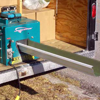 Seamless gutter machine in back of truck operating to create custom fit seamless gutters